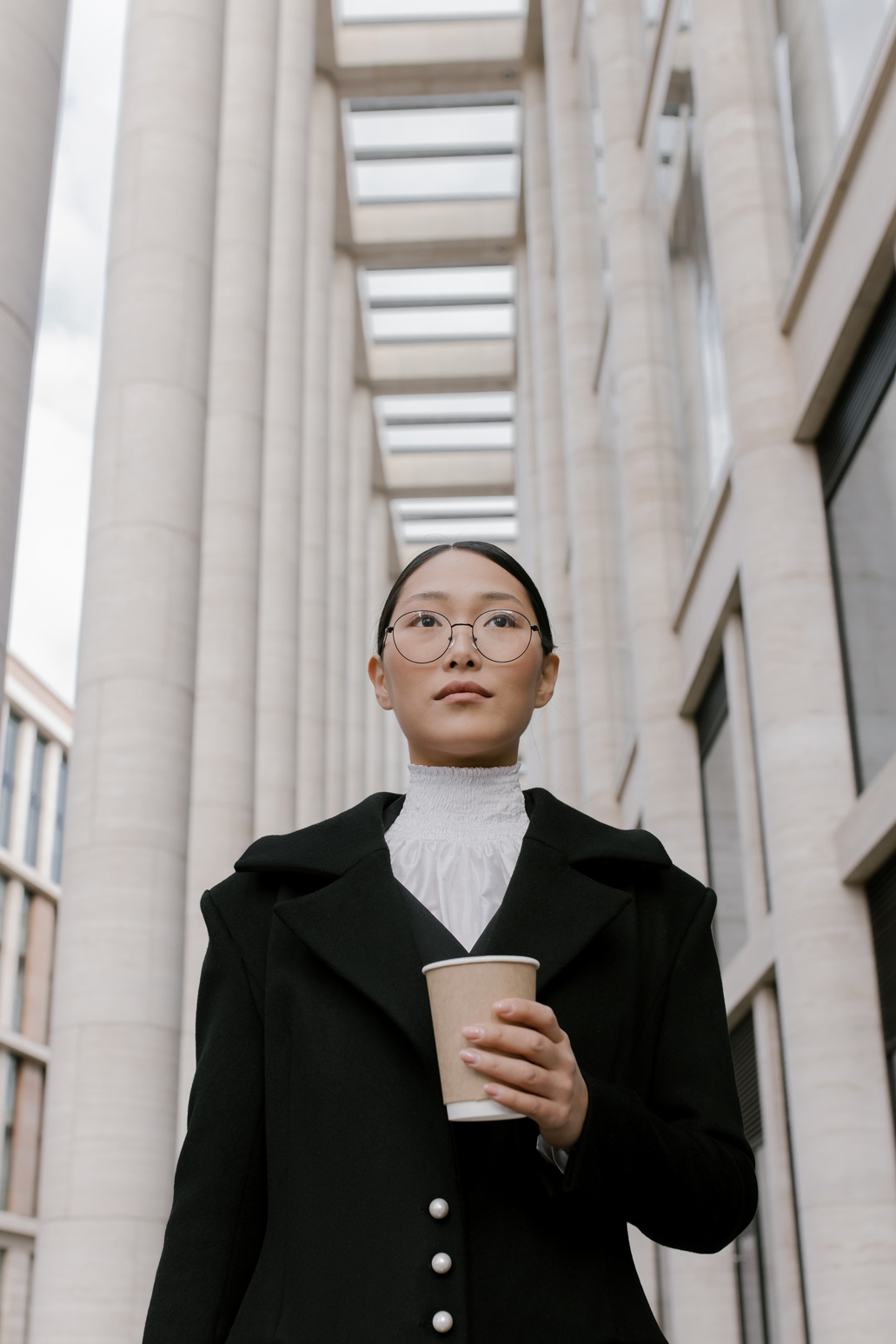 A Low Angle Shot of a Woman in Black Coat Holding a Cup of Coffee